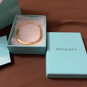 Tiffany and Co. bangle gold bracelet with diamond accents.